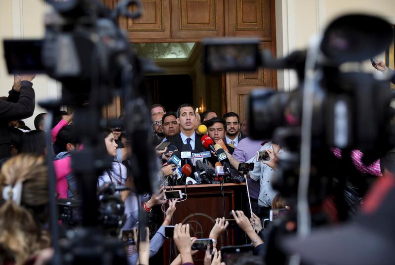 Opposition National Assembly President Juan Guaido, who declared himself interim president of Venezuela, speaks with the media outside the National Assembly, in Caracas, Venezuela, Tuesday, Jan. 29, 2019. Venezuela's chief prosecutor on Tuesday asked the country's top court to ban Guaido from leaving the country, launching a criminal probe into his anti-government activities while international pressure builds against President Nicolas Maduro. (AP Photo/Rodrigo Abd)