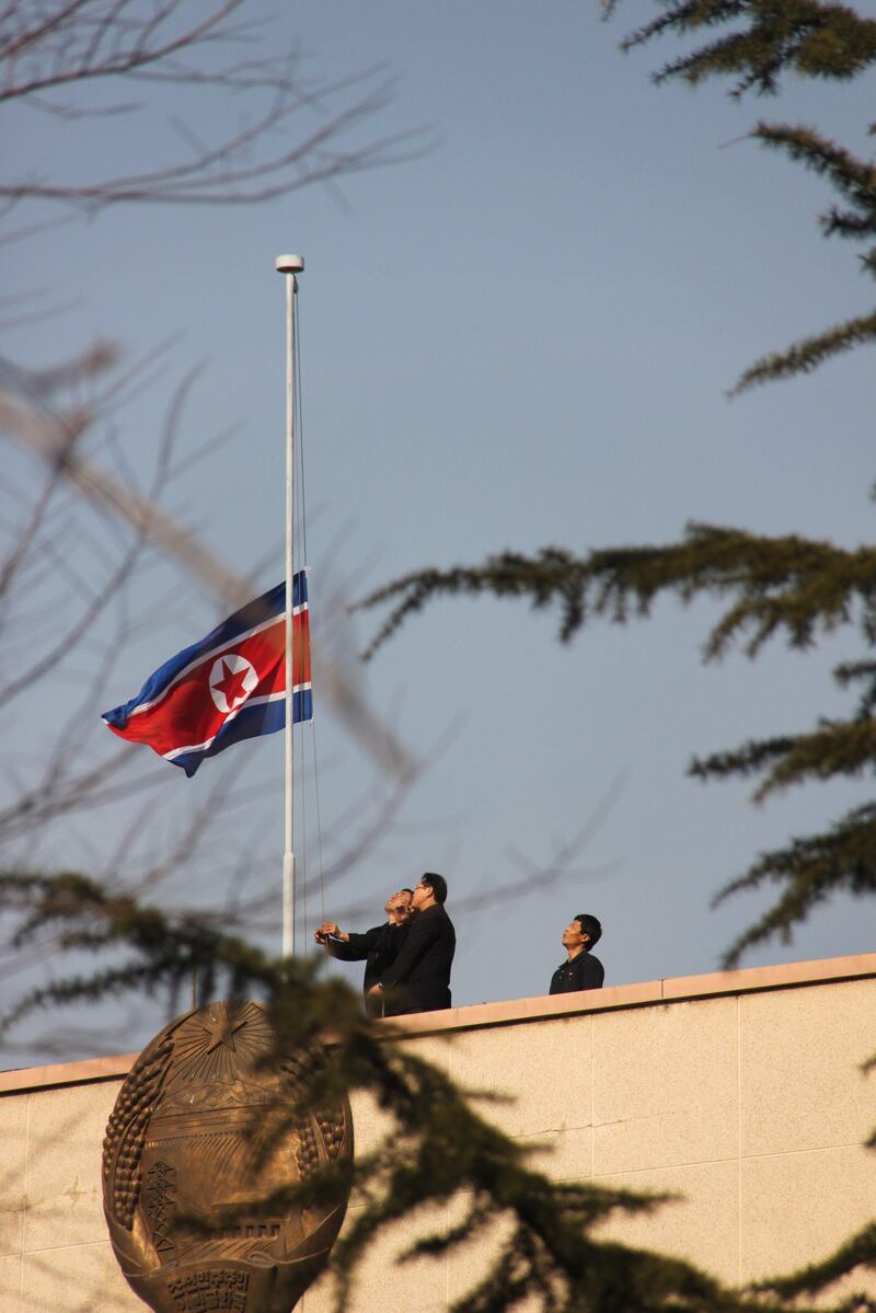 epa03038278 Officials at the North Korean Embassy in Beijing, China, lower the national flag in the morning of 19 December 2011 to mourn the death of North Korean leader Kim Jong-il. Earlier in the day, the North Korean Central News Agency (KCNA) said in an urgent dispatch that Kim died of a heart attack during a train ride on a field guidance trip on 17 December 2011.  EPA/YONHAP SOUTH KOREA OUT *** Local Caption ***  03038278.jpg