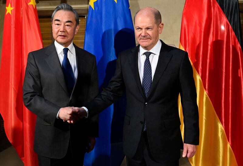 German Chancellor Olaf Scholz shakes hands with China's Director of the Office of the Central Foreign Affairs Commission, Wang Yi, at the Munich Security Conference on February 17, 2023. Thomas Kienzle / AFP