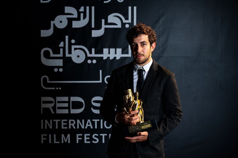 Jordanian film director Murad Abu Eisheh posing with his Short Competition Golden Yusr  award for his film 'Tala-Vision'. Photo: Red Sea International Film Festival / AFP
