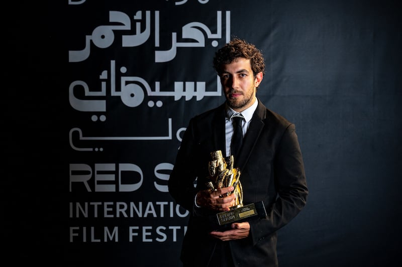 Jordanian film director Murad Abu Eisheh posing with his Short Competition Golden Yusr  award for his film 'Tala-Vision'. Photo: Red Sea International Film Festival / AFP