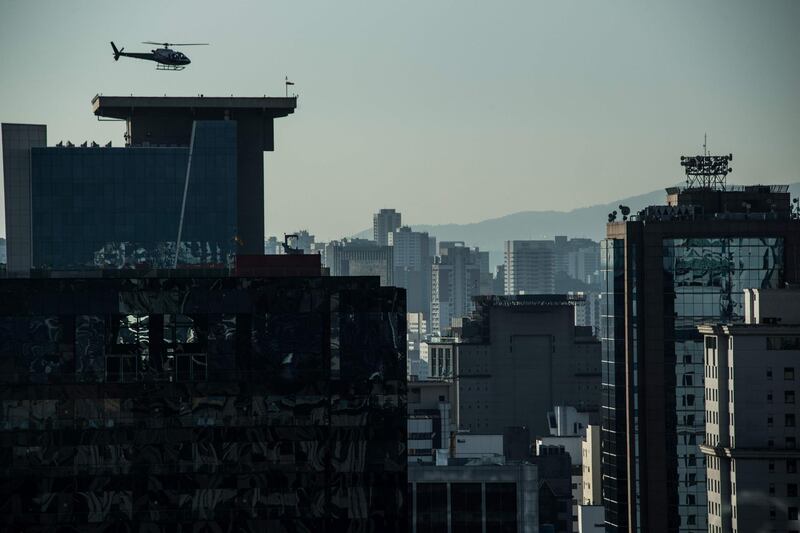 A helicopter lands on the roof of a building in downtown Sao Paulo, Brazil on June 23, 2017.
Airbus' subsidiary Voom gives an alternative for those willing to avoid Sao Paulo's heavy car traffic, offering a helicopter service similar to the car service offered by Uber. Sao Paulo counts one car every two inhabitants and during rush time there are between 330 and 576 km of traffic jams.  / AFP PHOTO / NELSON ALMEIDA
