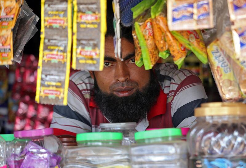 A man from the Rohingya community looks on as he sits inside his shop at a camp on the outskirts of Jammu. Reuters
