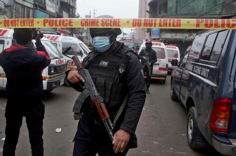 Police stand guard as ambulances prepare to transport injured people from the site of the explosion in which several people were killed and dozens wounded.  AP