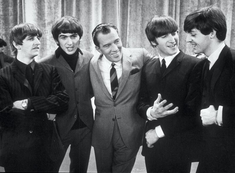 American television host Ed Sullivan smiles while standing with British rock group the Beatles on the set of his television variety series, New York, February 9, 1964. Left to right: Ringo Starr, George Harrison, Sullivan, John Lennon, Paul McCartney. (Photo by Express Newspapers/Getty Images) 