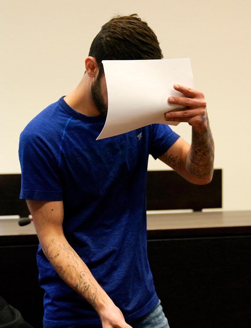 WIESBADEN, GERMANY - JULY 10: Defendant Ali B., who is accused of murder, covers his face as he arrives for sentencing at a courtroom on July 10, 2019 in Wiesbaden, Germany. The defendant was sentenced to life in prison for the rape and murder of 14 year old Susanna F. in Mainz. (Photo by Ronald Wittek - Pool/Getty Images)