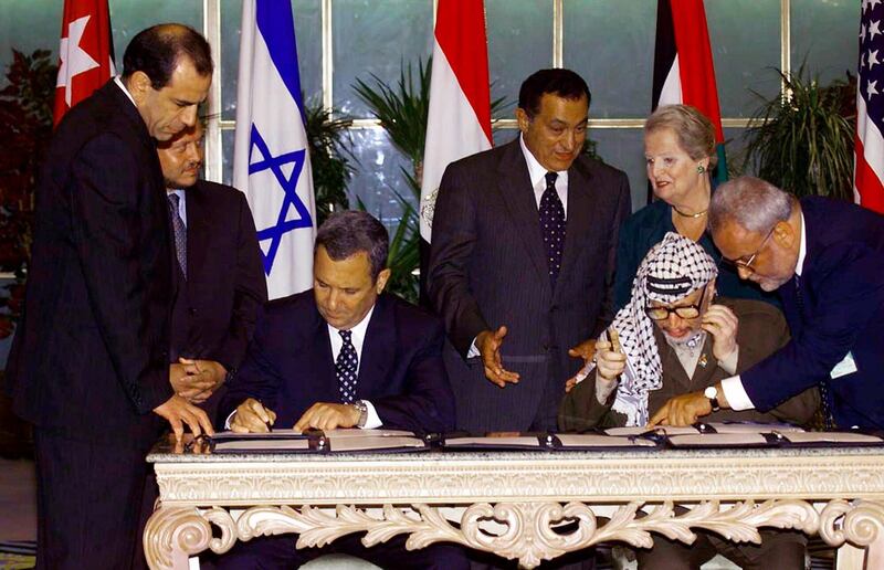 Palestinian leader Yasser Arafat, seated right, consults with Saeb Erekat, right, as Israeli Prime Minister Ehud Barak, seated left, sign a land-for-security agreement in the Egyptian resort town of Sharm el-Sheikh as US Secretary of State Madeleine Albright, background right, Egyptian President Hosni Mubarak, center background, and Jordan's King Abdullah II, left background, look on on September 5, 1999. AP Photo