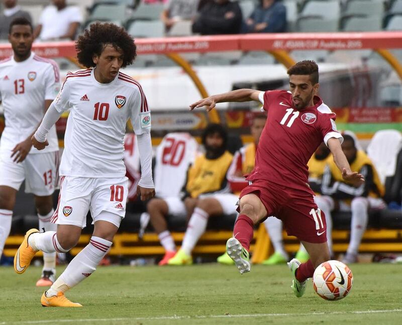 Omar Abdulrahman of the UAE goes past Hasan Al Haydos of Qatar during the Group C Asian Cup football match between UAE and Qatar in Canberra on January 11, 2015. AFP