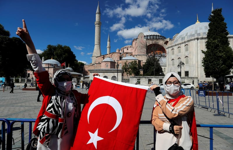 People carry a Turkish flag outside the Hagia Sophia or Ayasofya, a UNESCO World Heritage Site, which was a Byzantine cathedral before being converted into a mosque and currently a museum, in Istanbul, Turkey, July 10, 2020. REUTERS/Murad Sezer