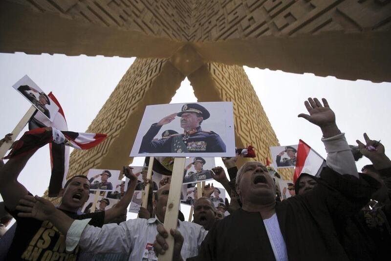 Supporters of the army hold posters of late Egyptian president Anwar Sadat as they protest against ousted Islamist president Mohammed Morsi and members of the Muslim Brotherhood at Sadat's tomb. Amr Abdallah / Reuters



