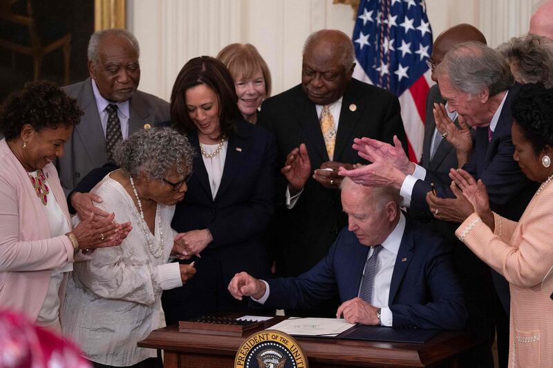 Opal Lee (2nd L), the activist known as the grandmother of Juneteenth, speaks watches with US Vice President Kamala Harris as US President Joe Biden looks on after signing the Juneteenth National Independence Day Act, in the East Room of the White House, June 17, 2021, in Washington. / AFP / Jim WATSON
