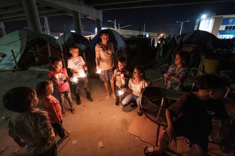 Children hold lit sparklers whilst celebrating Christmas Eve at an improvised shelter, set up under an overpass by people who lost their homes due to the floods caused by the rains brought by Hurricanes Eta and Iota, in San Pedro Sula, Honduras. Reuters