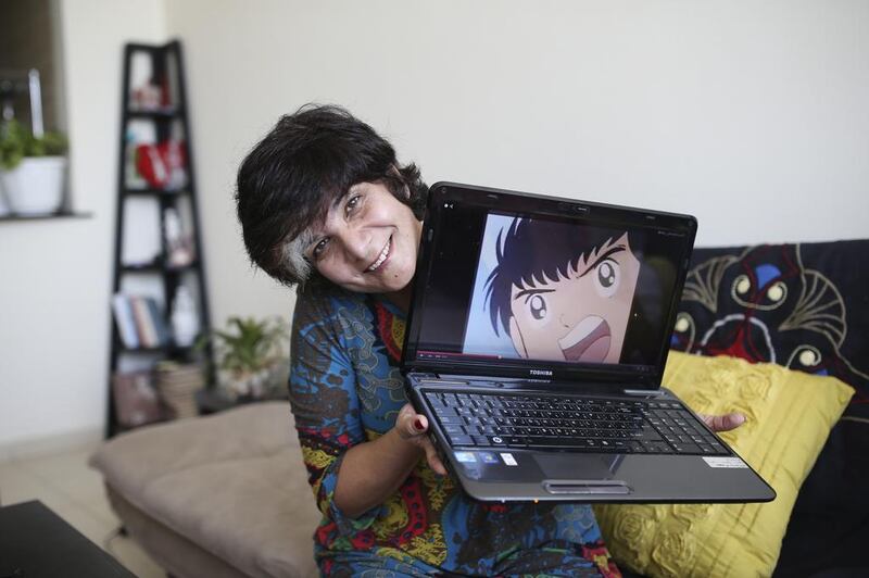 Syrian voice actress Amal Hawijeh photographed with Captain Majid, a character she voiced, in her home in Ajman. Sarah Dea / The National