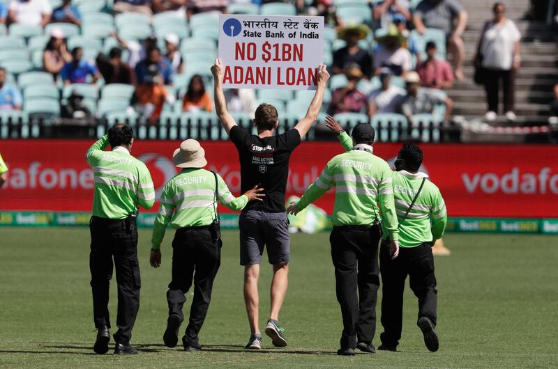 Security lead a protester from the field after he interrupted the first ODI in Sydney. AP