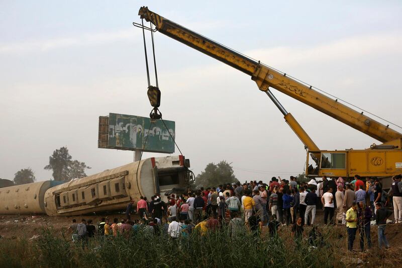A crane is used to lift a part of a passenger train that derailed injuring some 100 people, near Banha, Qalyubia province, Egypt. AP Photo