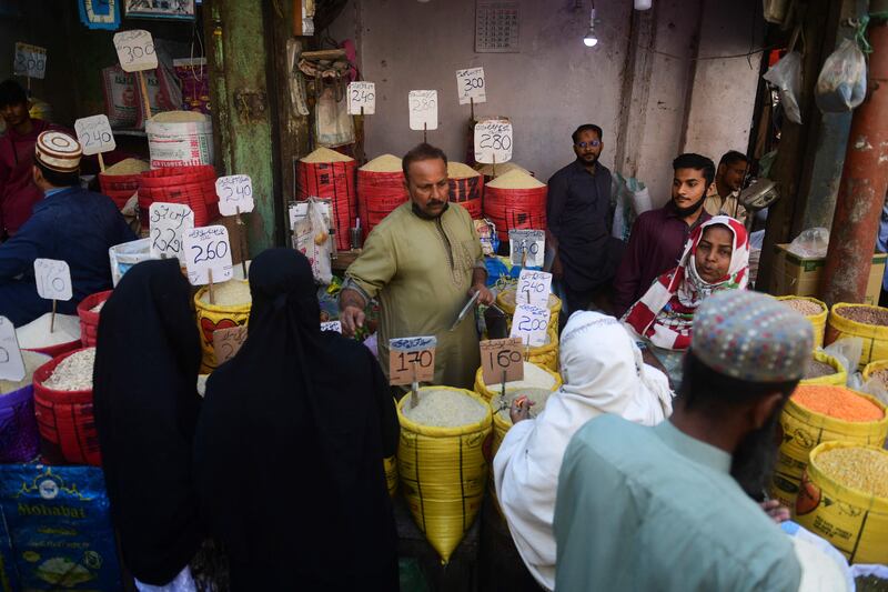 People buy rice at a market in Karachi on February 3, 2023.  - Pakistan's Prime Minister Shehbaz Sharif said February 3 the government would have to agree to IMF bailout conditions that are "beyond imagination", as it battles a spiralling economic crisis.  (Photo by Asif HASSAN  /  AFP)