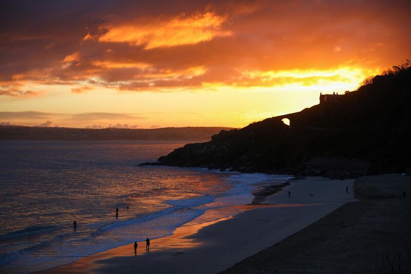 People walk on the Porthminster Beach at dawn on New Year's Day in St Ives, Cornwall. Reuters
