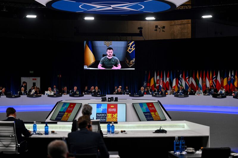 Ukrainian President Volodymyr Zelenskyy appears on a giant screen as he delivers a statement at the start of the first plenary session of the Nato summit. AFP