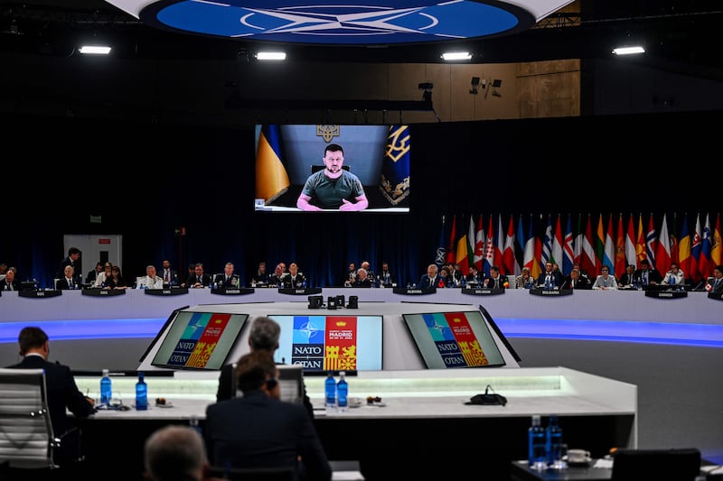 Ukrainian President Volodymyr Zelenskyy appears on a giant screen as he delivers a statement at the start of the first plenary session of the Nato summit. AFP