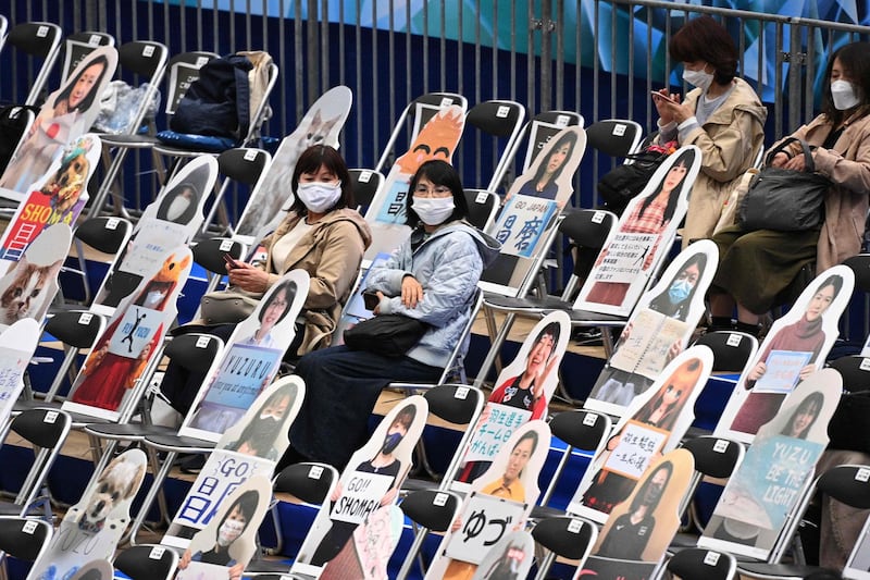 Spectators sit among seats with pictures of fans and animals ahead of the ISU World Team Trophy figure skating event in Osaka. AFP
