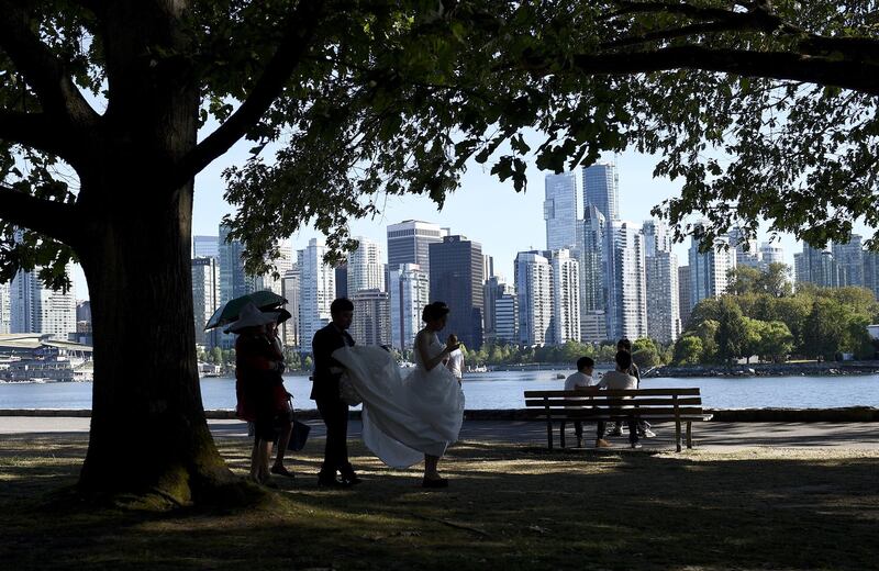 People are seen in Stanley Park that borders the downtown area of Vancouver, British Columbia on July 3, 2015. AFP PHOTO / FRANCK FIFE / AFP PHOTO / FRANCK FIFE