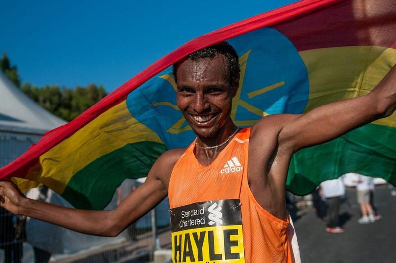 Lemi Berhanu Hayle shown with the Ethiopian flag after his win in the 2015 Dubai Marathon on Friday. Stephen Hindley / AP