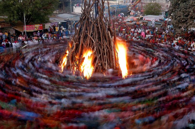 Hindu devotees walk around a bonfire during a ritual known as "Holika Dahan" which is part of Holi festival celebrations, in Ahmedabad, India, March 9, 2020. Picture taken with long exposure. Reuters