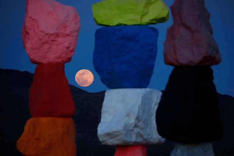 The pink supermoon rises behind the 'Seven Magic Mountains' artwork by Ugo Rondinone, in Las Vegas, US. AP Photo