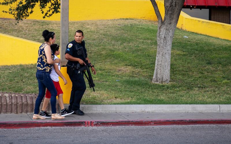 An Odessa police officer escort bystanders away from an area investigated for a shooting in Odessa, Texas following a deadly shooting. Several people were dead after a gunman who hijacked a postal service vehicle in West Texas shot more than 20 people, authorities said Saturday. The gunman was killed and a few law enforcement officers were among the injured. AP