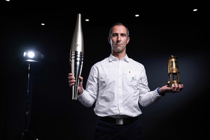 French skipper Armel Le Cleac'h poses with the Olympic torch and the Olympic lantern, in Paris. Navigator Mr Le Cleac'h will carry the Olympic flame from Brest to the Antilles next June in the ocean torch relay, which will visit six French overseas territories. AFP