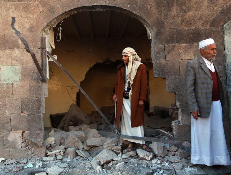 Shiite Houthis stand outside a building used by their police force after it was damaged in a bombing in Sanaa on January 5, 2015. Mohammed Huwais / AFP