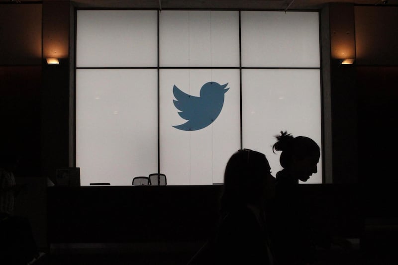 (FILES) In this file photograph taken on August 14, 2019, employees walk past an illuminated Twitter logo as they leave the company's headquarters in San Francisco. Twitter said May 12, 2020 it is unlikely to open its offices before September, and that many of its employees will be permitted to work from home permanently even after the end of the coronavirus lockdowns. The San Francisco-based company said it was among the first to move to telework in March as a result of the health crisis and that it will continue that policy indefinitely as part of a move towards a "distributed workforce."
 / AFP / Glenn CHAPMAN
