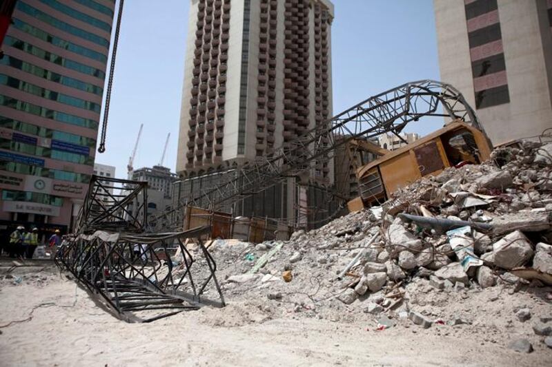 Construction workers work away to clean up remains of a crane that collapsed earlier that morning on Tuesday, July 12, 2011, during the morning rush hour in downtown Abu Dhabi. No one was hurt and only road blocks and the crane itself suffered damages. (Silvia Razgova/The National)

