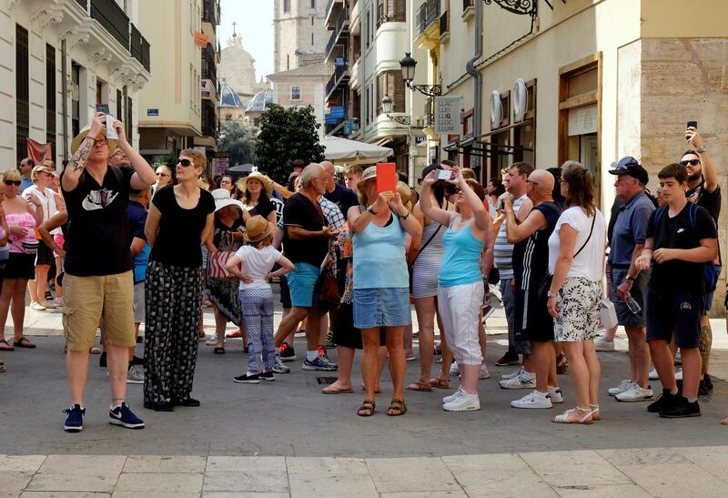 A group of tourists takes pictures during a visit in the Old Town of Valencia, Spain, August 17, 2017. REUTERS/Heino Kalis