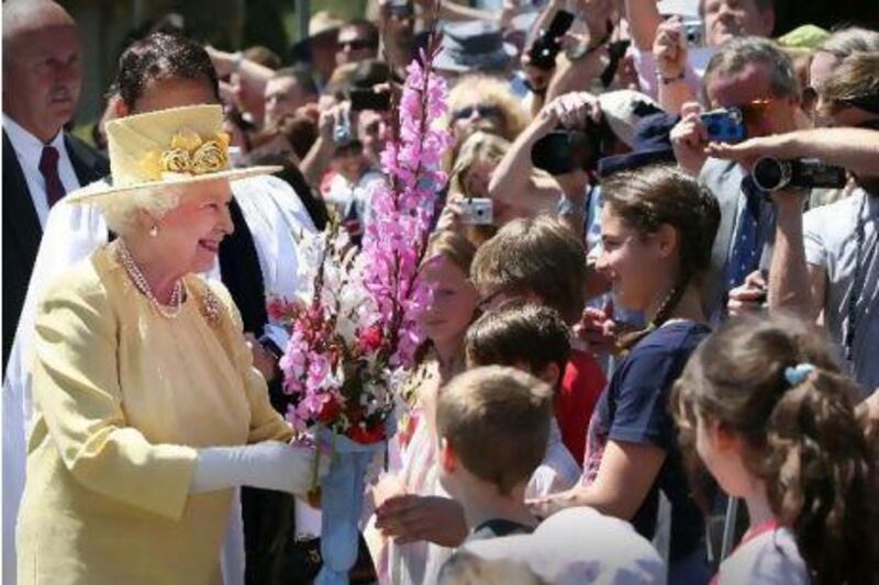 Britain's Queen Elizabeth receives flowers from the crowd after she attended church services at St John's Anglican church in Canberra on Sunday. Queen Elizabeth is in Australia for an 11-day official visit.