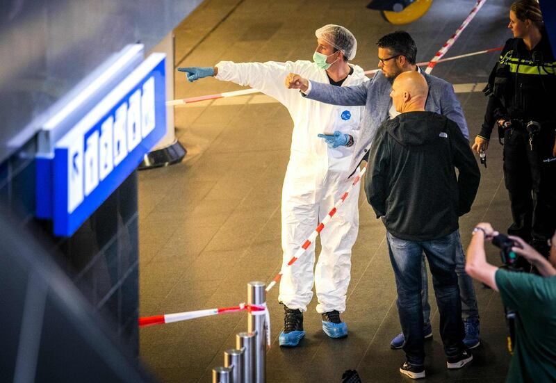 Policemen and forensics are at work after a stabbing incident at the central station in Amsterdam, on August 31, 2018. - The Police have shot a suspect after two people were stabbed. The stabbing was possibly an act of terrorism, said the police. The suspect and two other people who were injured in the stabbing incident were taken to hospital. (Photo by Remko de Waal / ANP / AFP) / Netherlands OUT