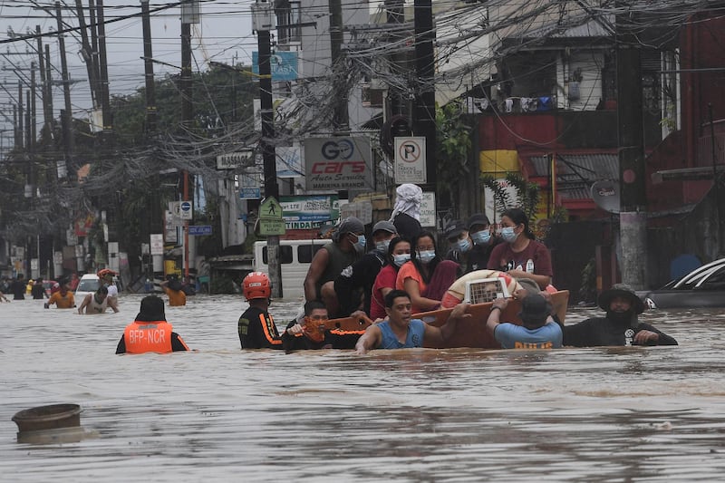 Rescuers evacuate residents from their flooded homes after Typhoon Vamco hit, in Marikina City. AFP