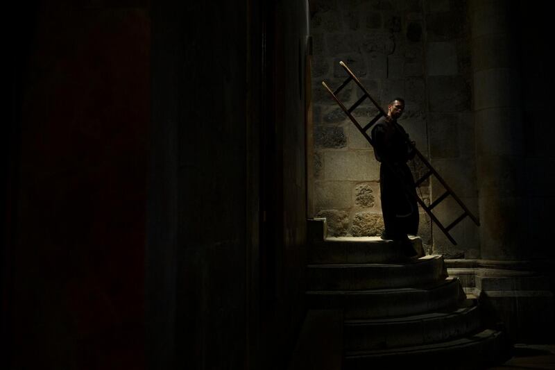 A priest carries a ladder used as a barrier to a chapel during mass at the Church of the Holy Sepulchre, where Jesus Christ is believed to be buried, in the Old City of Jerusalem. AP Photo