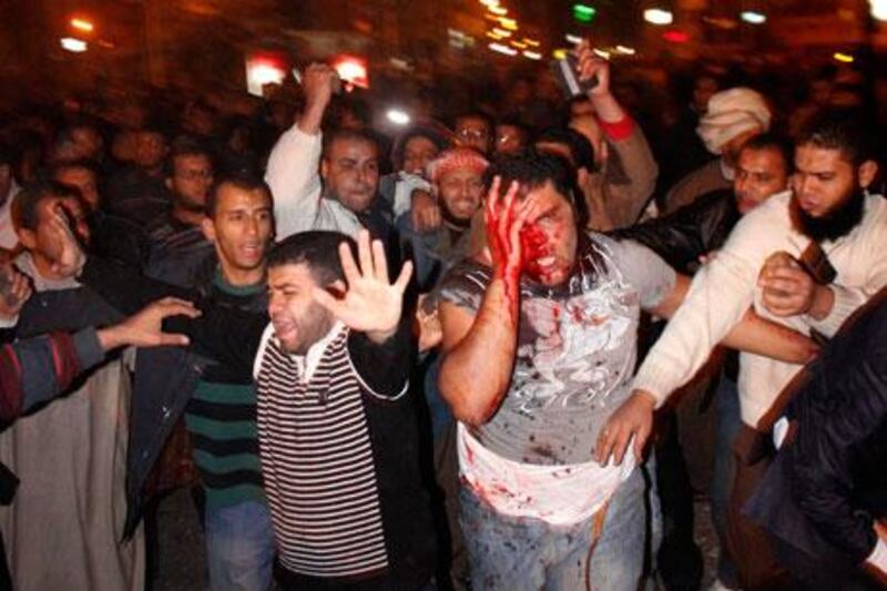 A wounded protester tries to leave the centre of clashes between supporters and opponents of Egyptian president Mohammed Morsi outside the presidential palace in Cairo last night.