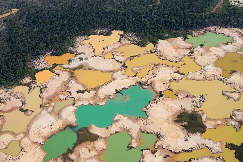 (FILES) A file photo taken on May 17, 2019 shows an aerial view over a chemically deforested area of the Amazon jungle caused by illegal mining activities in the river basin of the Madre de Dios region in southeast Peru, during the 'Mercury' joint operation by Peruvian military and police ongoing since February 2019. Climate change combined with galloping tropical deforestation is cutting off wildlife from life-saving cooler climes, heightening the risk of extinction, researchers said on July 8, 2019. Less than two-fifths of forests across Latin America, Asia and Africa currently allow for animals and plants to avoid potentially intolerable increases in temperature, they reported in the journal Nature Climate Change. / AFP / Cris BOURONCLE

