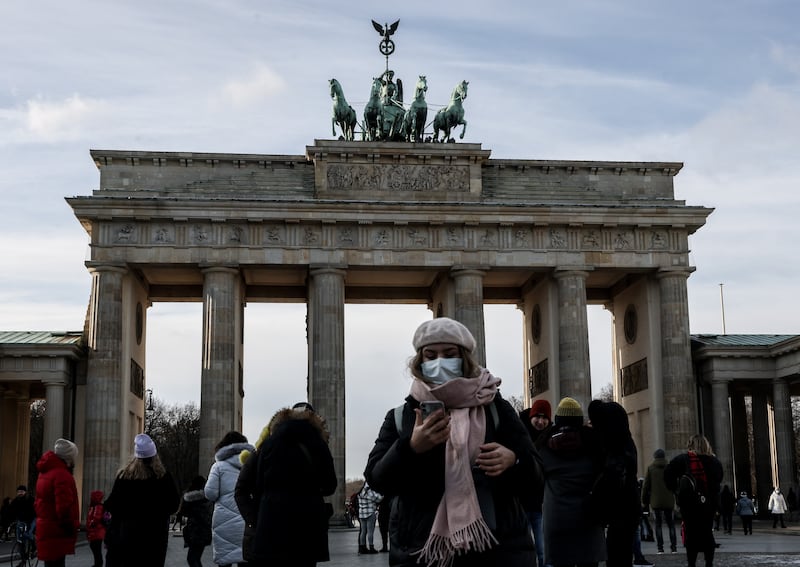 A woman wears a face mask in front of the Brandenburg Gate in Berlin, Germany. EPA