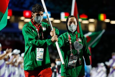 Hossain Rasouli and Zakia Khudadadi carry the flag of Afghanistan during the closing ceremony for the Tokyo 2020 Paralympic Games. Reuters