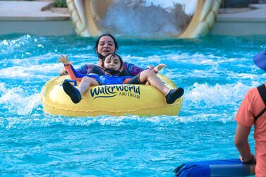 Abu Dhabi, United Arab Emirates, August 4, 2020. Yas Waterworld Abu Dhabi opens with 30% capacity as Covid-19 restrictions slowly come to an ease. A mother and her son come out of one of the giant slides at the waterpark. Victor Besa /The National Section: NA Reporter: