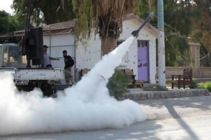 Members of the Free Syrian Army fire a homemade rocket towards forces loyal to Syria's president Bashar Al Assad in Deir Al Zor.