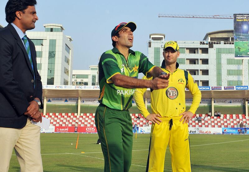 Pakistani cricket captain Misbah ul-Haq (C) tosses a coin next to Australian captain Michael Clarke before the start the first One Day International cricket match between Pakistan and Australia at the Sharjah cricket stadium on August 28, 2012.  Pakistan captain Misbah-ul Haq won the toss and opted to bat against Australia in the first of three limited overs internationals at Sharjah Stadium. AFP PHOTO / Aamir QURESHI
 *** Local Caption ***  324901-01-08.jpg