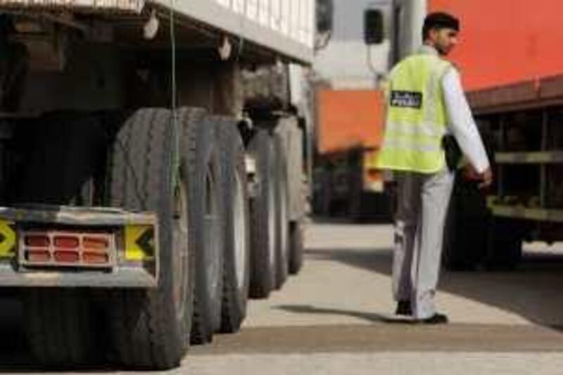 ABU DHABI, UNITED ARAB EMIRATES - June 7, 2009: Traffic Police Officer, Mohammed Al Mazrouei inspects a truck for legal tires, reflective stickers, insurance, valid driver's license, and license plates, in part of an ongoing campaign to make increase safety on the roads of Abu Dhabi. 
( Ryan Carter / The National ) *** Local Caption ***  RC003-TruckInspection.JPGRC003-TruckInspection.JPG