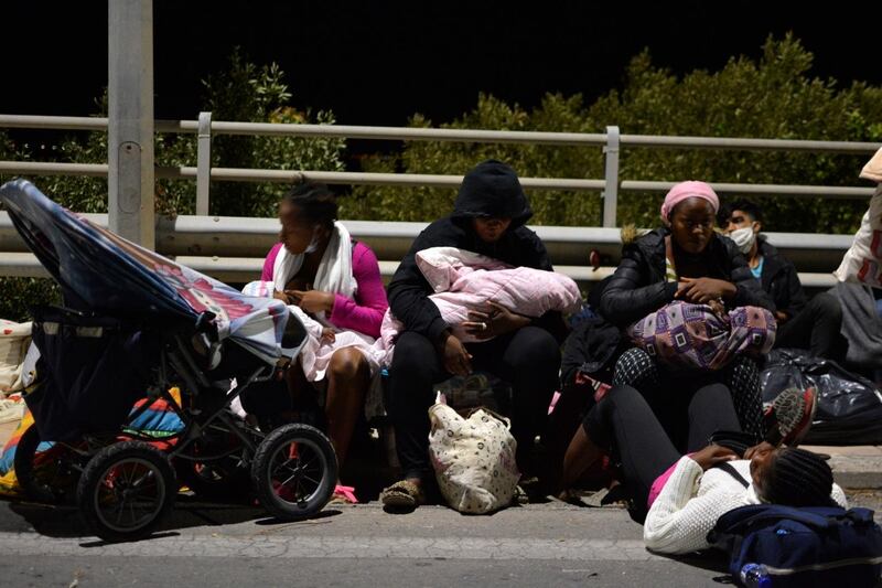 Refugees and migrants with their children gather on a bridge as fire burns at the Moria refugee camp on the northeastern Aegean island of Lesbos, Greece. AP Photo