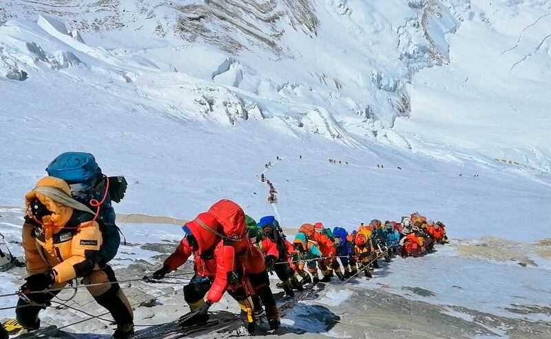 In this May 22, 2019 photo, a long queue of mountain climbers line a path on Mount Everest just below camp four, in Nepal. Seasoned mountaineers say the Nepal government's failure to limit the number of climbers on Mount Everest has resulted in dangerous overcrowding and a greater number of deaths. (AP Photo/Rizza Alee)