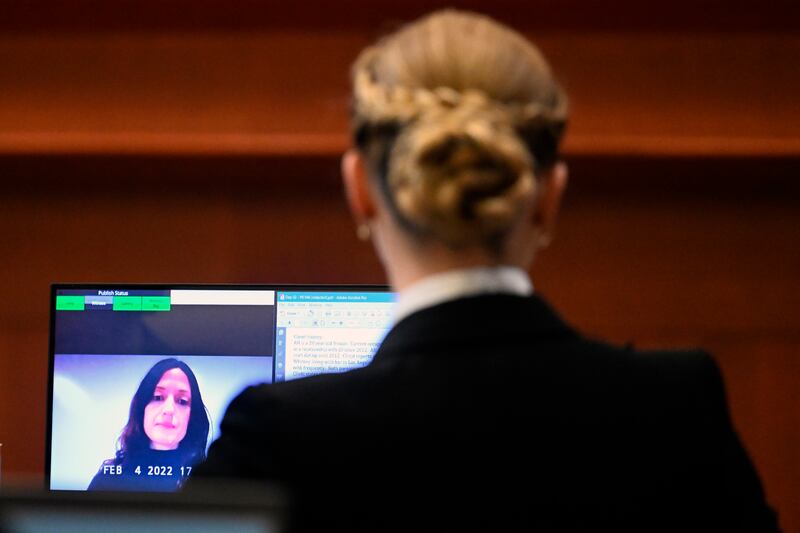 Amber Heard listens as Erin Falati, a former nurse, speaks via video conference. AP