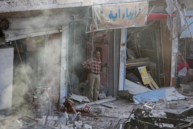 A Syrian man inspects the site of a car bomb explosion. AFP